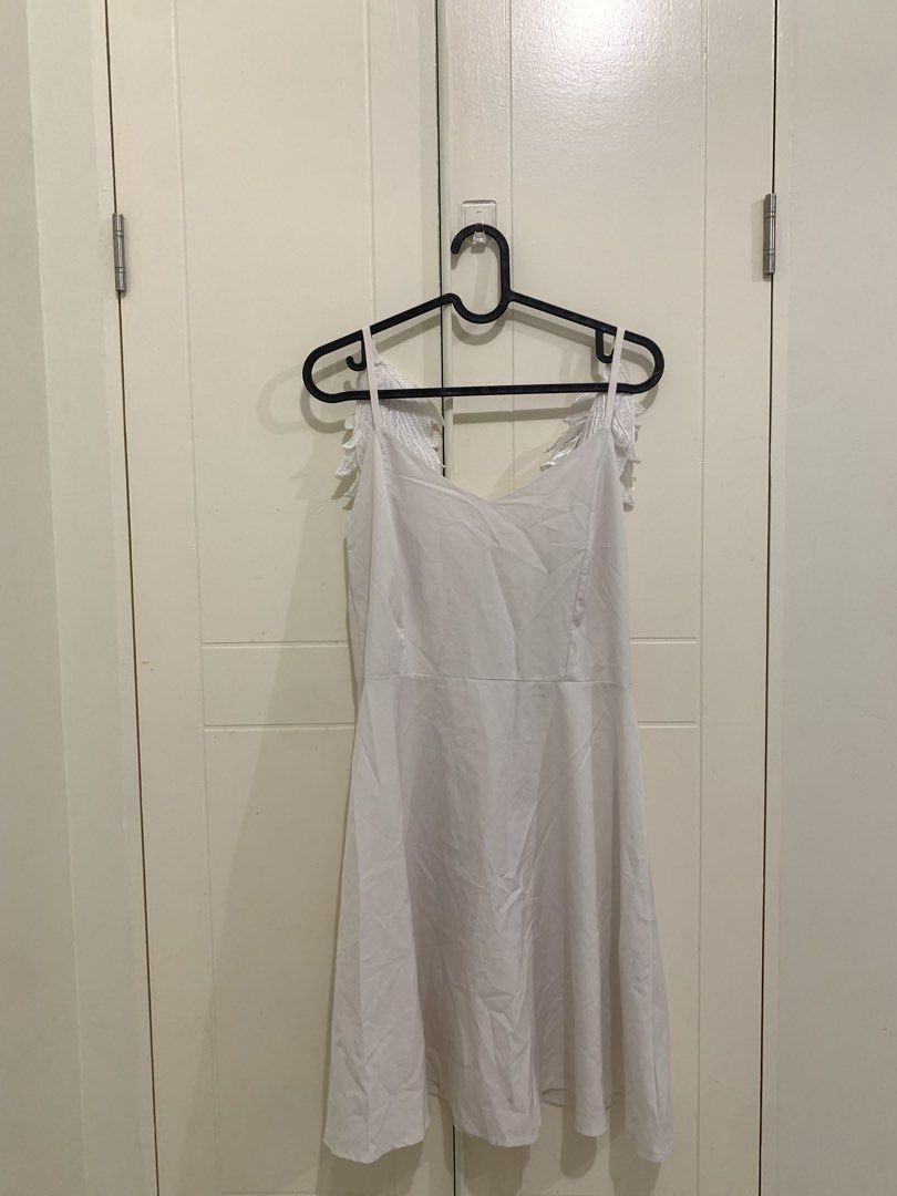 White Dress with Angel Wing Straps (Category: Dresses) located in Pasig City. Submitted by lovedbyri (Listing ID 1471016809, Image 1). Description: - Style: White sleeveless midi dress with a flared skirt - Unique Details: Embroidered leaf or wing accents hanging from the straps down the back, plus a stylish upper back cutout - Length: Midi - Color/Fabric: Clean neutral fabric, perfect for various occasions - Closure: Simple zip or slip construct