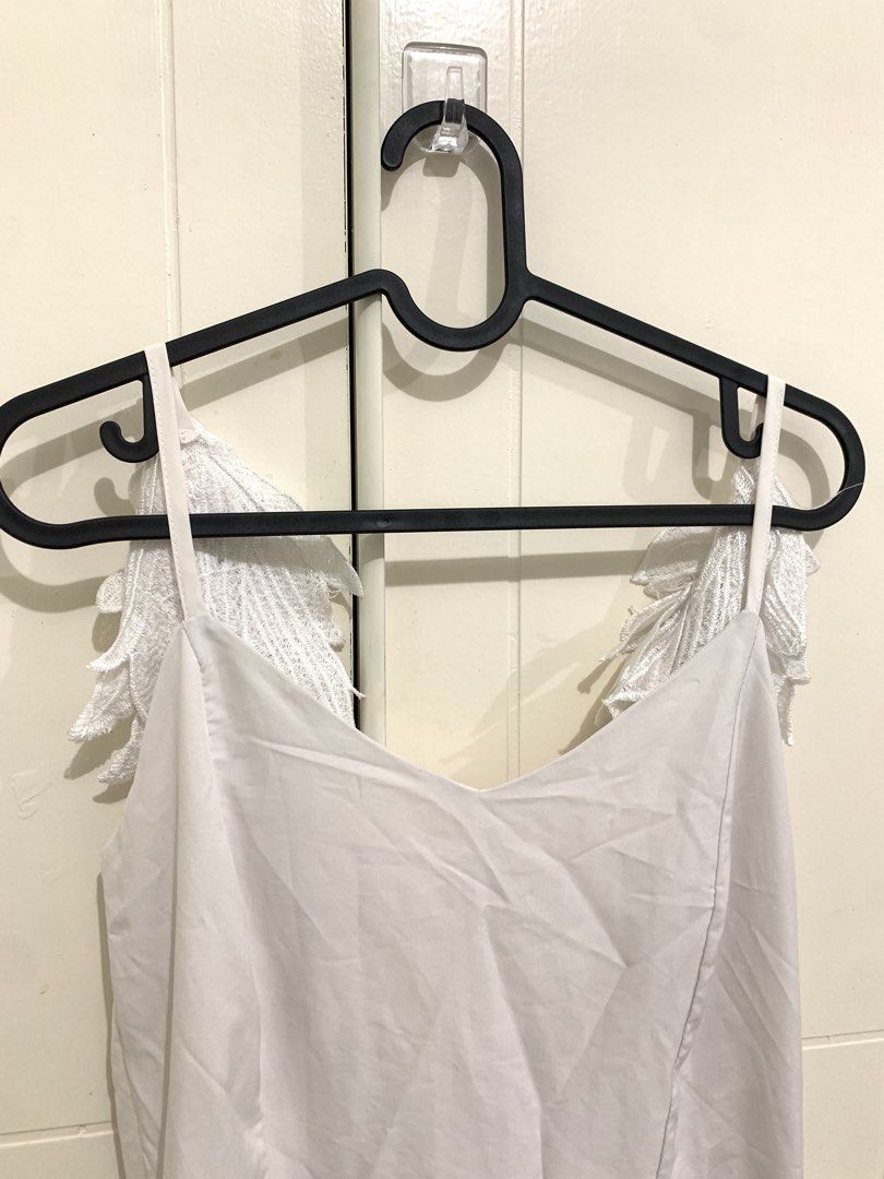 White Dress with Angel Wing Straps (Category: Dresses) located in Pasig City. Submitted by lovedbyri (Listing ID 1471016809, Image 2). Description: - Style: White sleeveless midi dress with a flared skirt - Unique Details: Embroidered leaf or wing accents hanging from the straps down the back, plus a stylish upper back cutout - Length: Midi - Color/Fabric: Clean neutral fabric, perfect for various occasions - Closure: Simple zip or slip construct