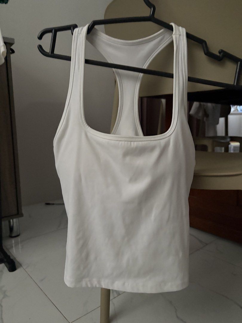 White Racerback Athletic Tank Top (Category: Activewear) located in Manila. Submitted by mika_declutter (Listing ID 1470943900, Image 1). Description: - Color: Solid white - Style: Athletic tank top with trendy square neckline and racerback - Comfort: Soft, stretchy fabric perfect for workouts or casual wear - Extra: Built-in bra lining for added support - Condition: Clean, no stains or marks.