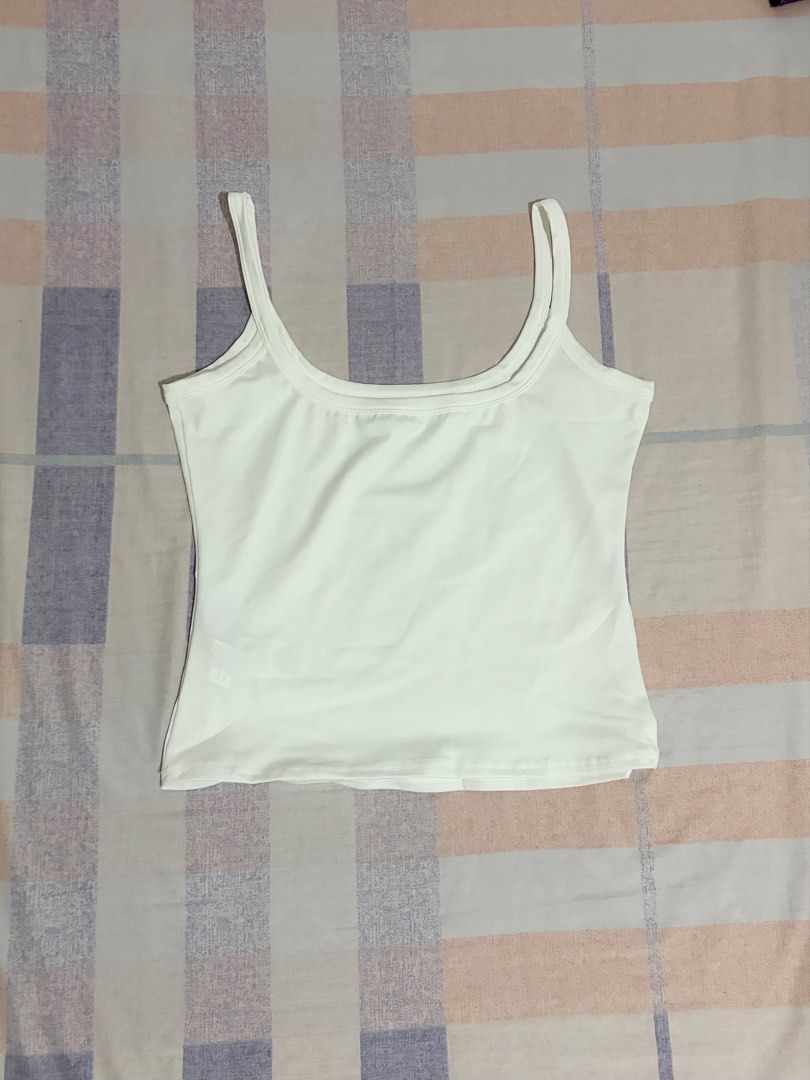 White scoop neck tank top Y2K (Category: Sleeveless) located in Las Pinas. Submitted by hanrue12 (Listing ID 1470970357, Image 2). Description: - Color: Solid white - Style: Scoop neck, fitted cut with wide straps - Material: Soft and stretchy fabric - Versatility: Great everyday basic, easy to mix and match with jeans, skirts, or shorts - Condition: Clean, no stains or damage, ready to wear.