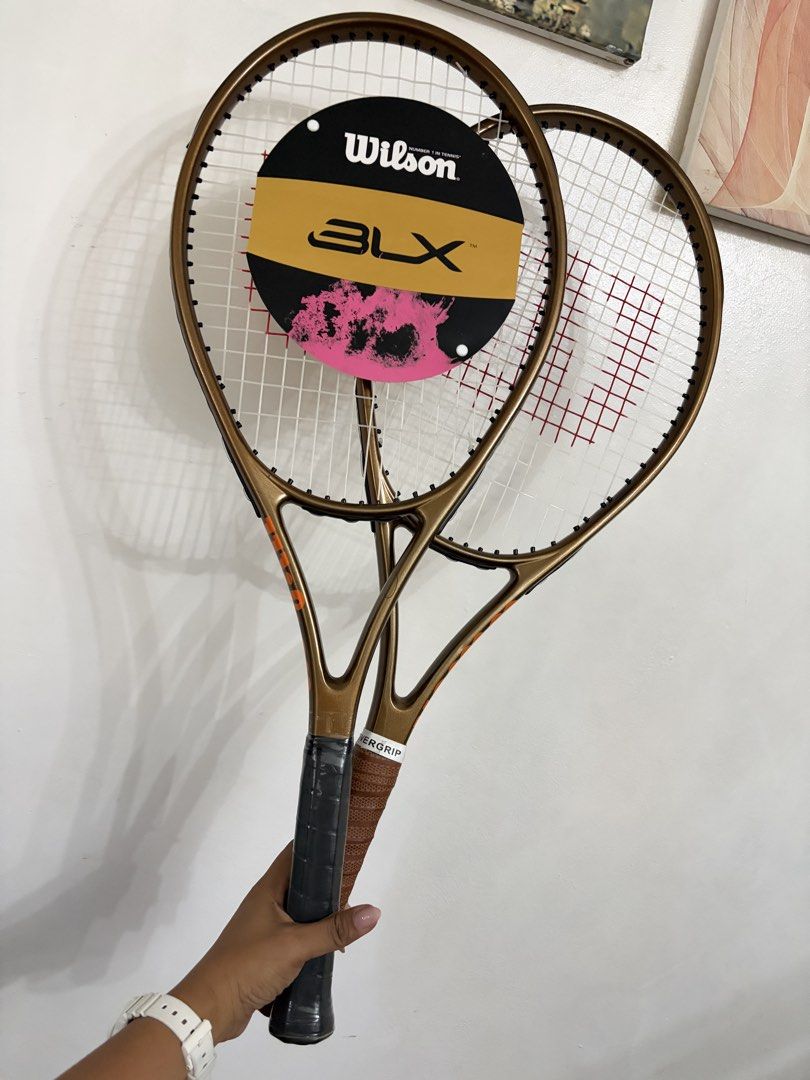 Wilson tennis racket (Category: Racket and Ball Sports) located in Taytay. Submitted by murahubblueapppage (Listing ID 1471028820, Image 1). Description: two bronze-colored Wilson Pro 97 Staff V14 tennis racquets featuring a signature metallic earth-tone finish and a round Wilson BLX-branded hangtag on the strings The other One is brand new And the other one used twice only for affiliates only With case For both.