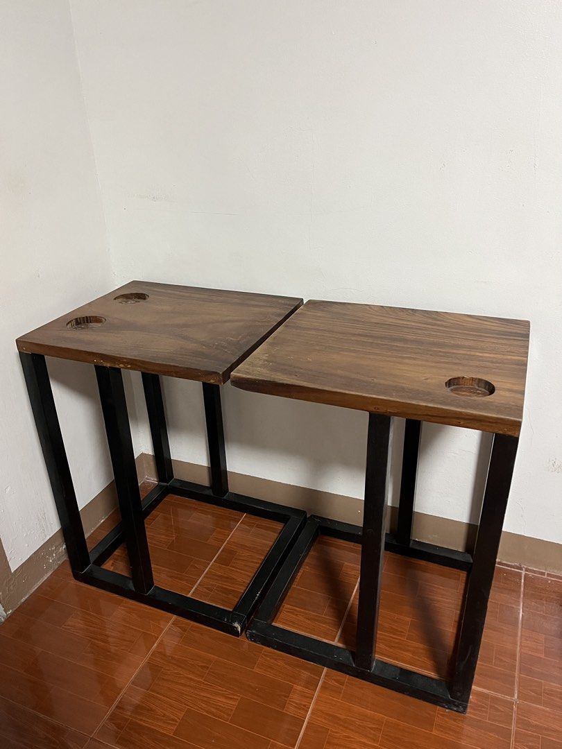 Wooden C-Shaped Side Table Set of Two (Category: Tables & Sets) located in Cabuyao City. Submitted by rdtrmt (Listing ID 1470990529, Image 3). Description: - Set of Two of Wooden C-shaped side table - Made of solid dark wood, natural wood grain top and a black metal frame - Crafted from thick, polished dark wood showing visible grain patterns, featuring built-in circular cup holders or recessed slots near the back edge. - Built with a geometric b