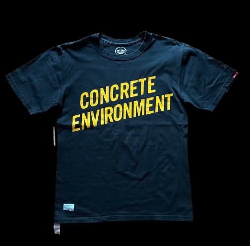 WTAPS Concrete Environment Black T-Shirt (Category: Tshirts & Polo Shirts ) located in Caloocan City. Submitted by landcruiser76__ (Listing ID 1471077156, Image 1). Description: - Brand: WTAPS - Color: Black with bold yellow 'CONCRETE ENVIRONMENT' chest graphic - Details: Small upper back print, woven front hem logo patch, and signature red sleeve tag - Fit: Regular crew neck cut - Condition: Pre-loved with normal signs of wear - Mode of Payment:
