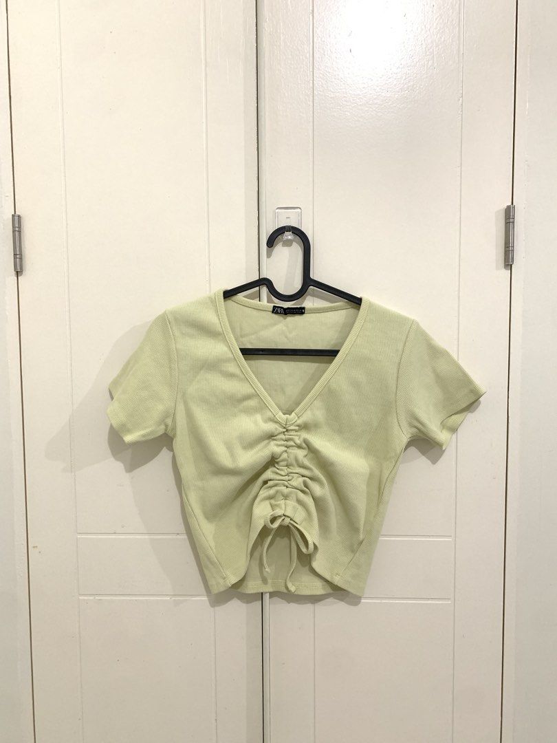 Yellow Ribbed V-Neck Ruched Crop Top (Category: Sleeveless) located in Pasig City. Submitted by lovedbyri (Listing ID 1470956249, Image 1). Description: - Size: Medium - Color: Light yellow - Material: Ribbed knit - Design: Short sleeves, V-neck, and adjustable front drawstring for a ruched style - Condition: Excellent, clean fabric with no stains or loose threads.