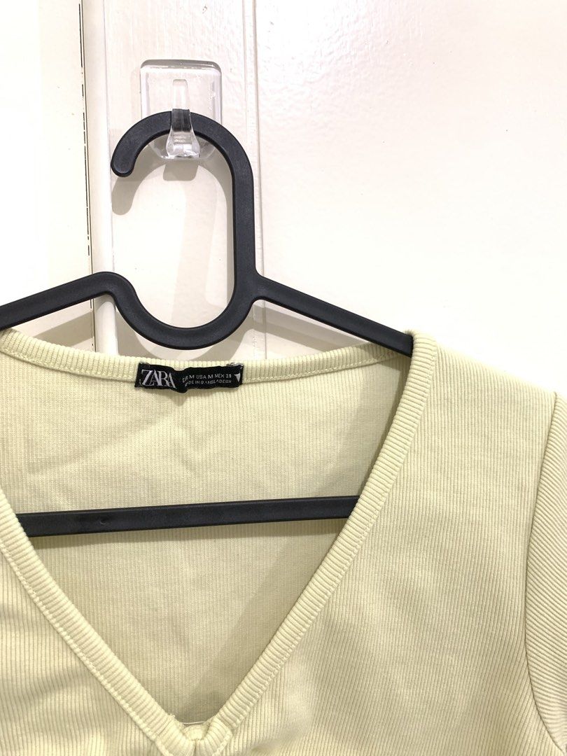 Yellow Ribbed V-Neck Ruched Crop Top (Category: Sleeveless) located in Pasig City. Submitted by lovedbyri (Listing ID 1470956249, Image 2). Description: - Size: Medium - Color: Light yellow - Material: Ribbed knit - Design: Short sleeves, V-neck, and adjustable front drawstring for a ruched style - Condition: Excellent, clean fabric with no stains or loose threads.