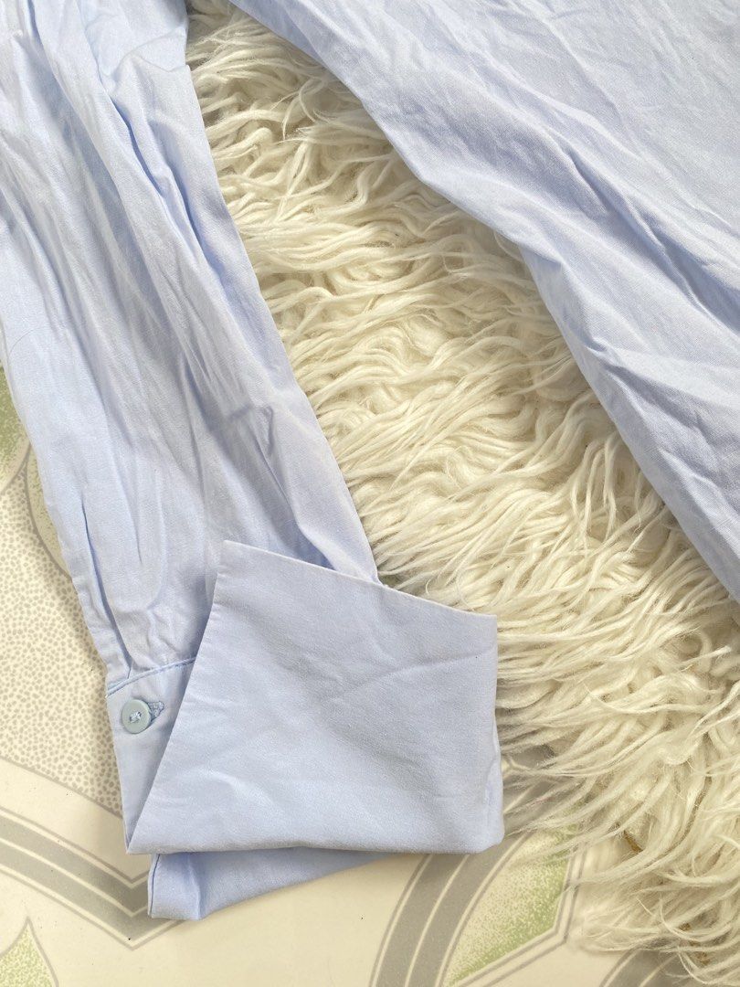 Zara Basic Light Blue Long Sleeve Button Up Shirt (Category: Longsleeves) located in Tabaco. Submitted by camila_p (Listing ID 1470986800, Image 3). Description: - Brand: Zara Basic - Color: Light Blue - Size: S - Style: Long sleeve button-up with classic collar and front button closure - Design Details: Wide cuffs and unique open-back wrap detail - Versatility: Great for layering or solo wear - Condition: Clean with light wrinkling from storage.