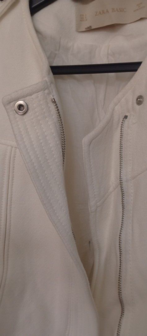 Zara Basic White Biker Jacket Size S (Category: Coats, Jackets and Outerwear) located in Manila. Submitted by charlottej01596 (Listing ID 1470946554, Image 3). Description: - Brand: Zara Basic - Size: S (EUR S, USA S, MEX 26) - Details: Silver-tone zippers, snap buttons on shoulders and collar, two front zipped pockets - Origin: Made in Morocco - Condition: Clean finish, great for everyday wear.