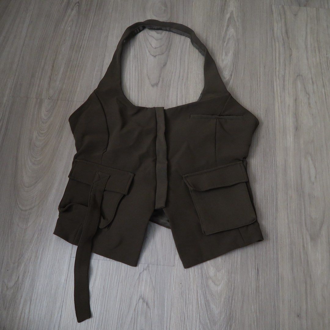 ZARA Brown Halter Vest Top Size S (Category: Sleeveless) located in Manila. Submitted by mairalyng21434 (Listing ID 1471038190, Image 1). Description: - Brand: Zara - Size: Small - Color: Brown - Origin: Made in Morocco - Design: Halter vest top with front button closure, utility pockets, strap detail, and open back - Styling tip: Pairs well with high-waisted jeans or trousers.