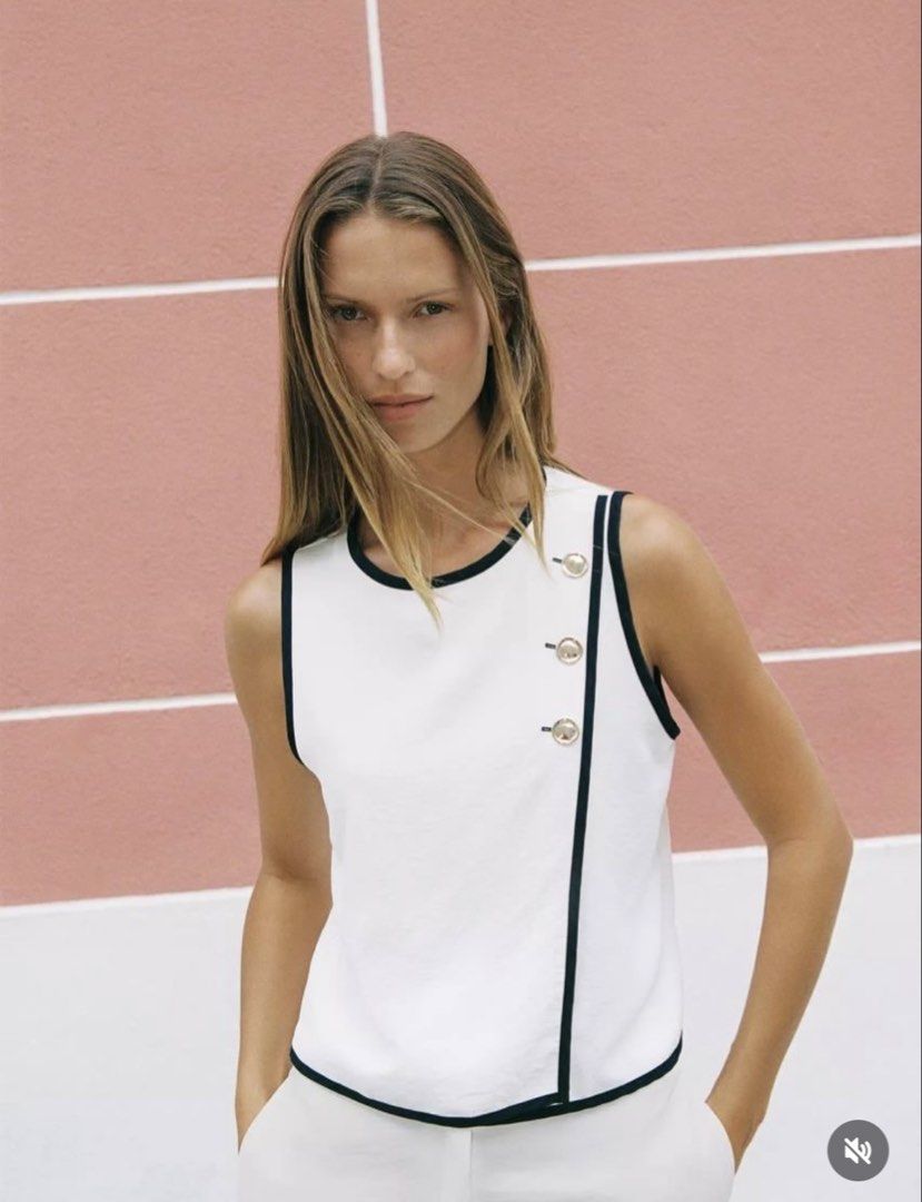 Zara Contrast Piping Top (Category: Sleeveless) located in Manila. Submitted by mazhktis.ndhdjssj79 (Listing ID 1470994562, Image 3). Description: - Size: S - Color: White with dark contrast piping - Design: Asymmetric front overlap with 3 metallic shoulder buttons - Material: Lightweight, clean-cut fabric - Perfect for smart-casual or chic everyday wear.