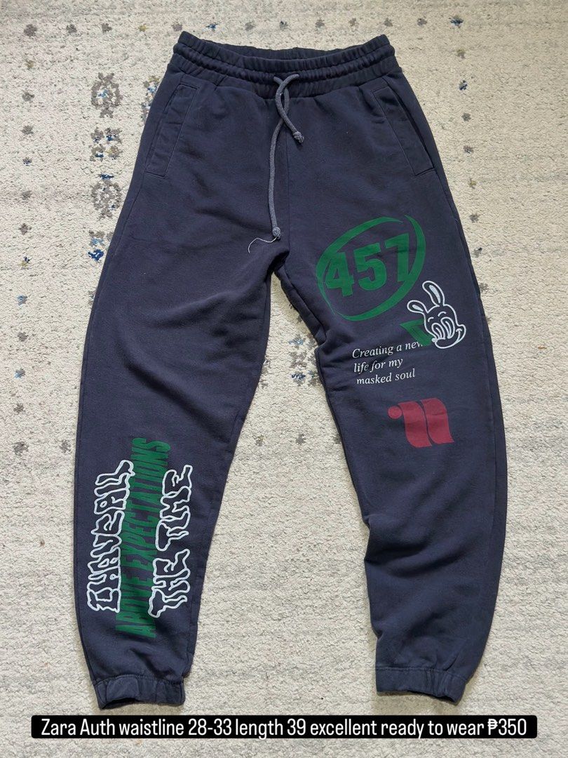 Zara Graphic Print Jogger Sweatpants (Category: Joggers) located in Daet. Submitted by thrifthings2018 (Listing ID 1471011956, Image 1). Description: - Brand: Authentic Zara - Size: Small (S) - Color: Dark Grey - Design: Assorted streetwear graphic prints and text on front and back - Fit: Elastic waistband with adjustable drawstring and ribbed ankle cuffs - Pockets: Convenient side pockets and one back pocket - Origin: Made in Turkey - Condition: