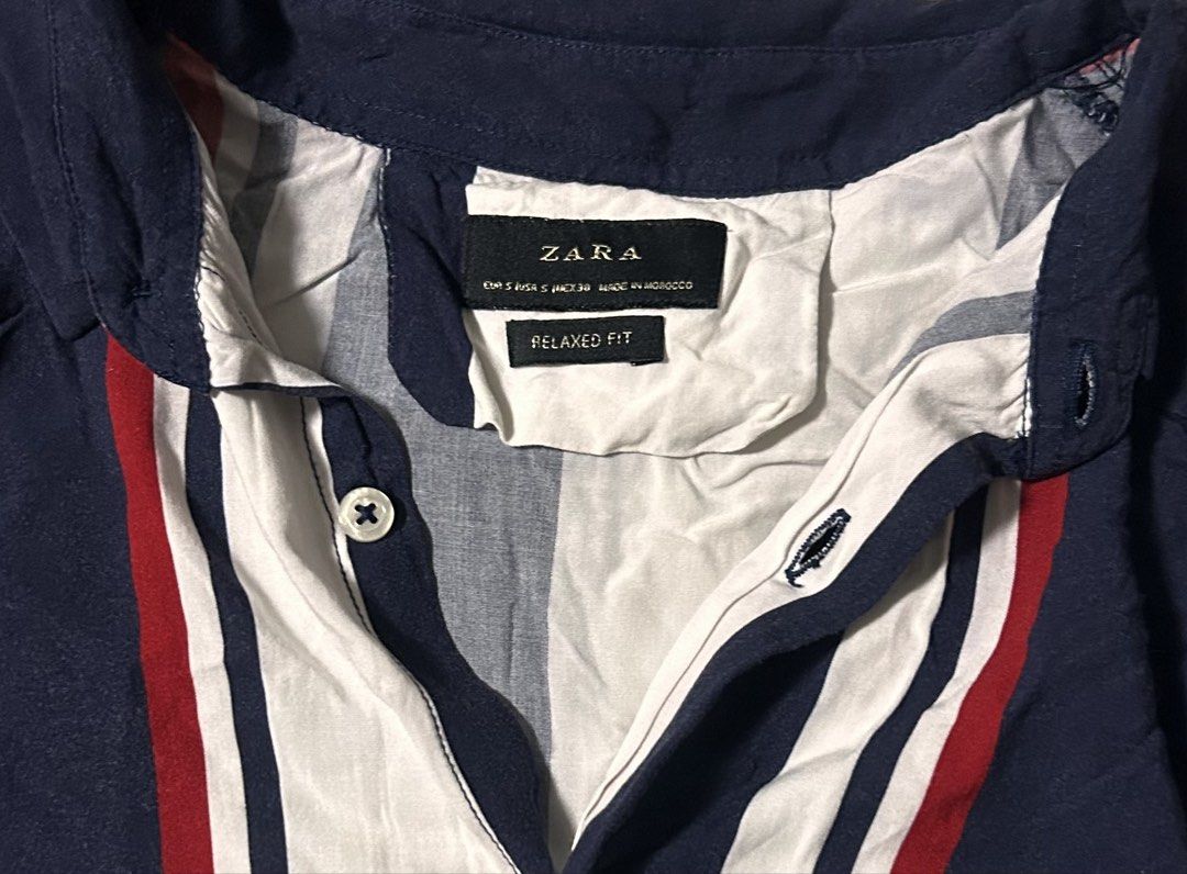 ZARA MAN (Category: Tshirts & Polo Shirts ) located in Davao. Submitted by sart0ria85 (Listing ID 1471083520, Image 3). Description: Zara short sleeve shirt in a relaxed fit. Navy blue base with bold vertical stripes in white and red. Open collar design and front button closure. Made from 100% VISCOSE. MADE IN MOROCCO 🇲🇦 SMALL. Size for men. VERY GOOD CONDITION (88/100).