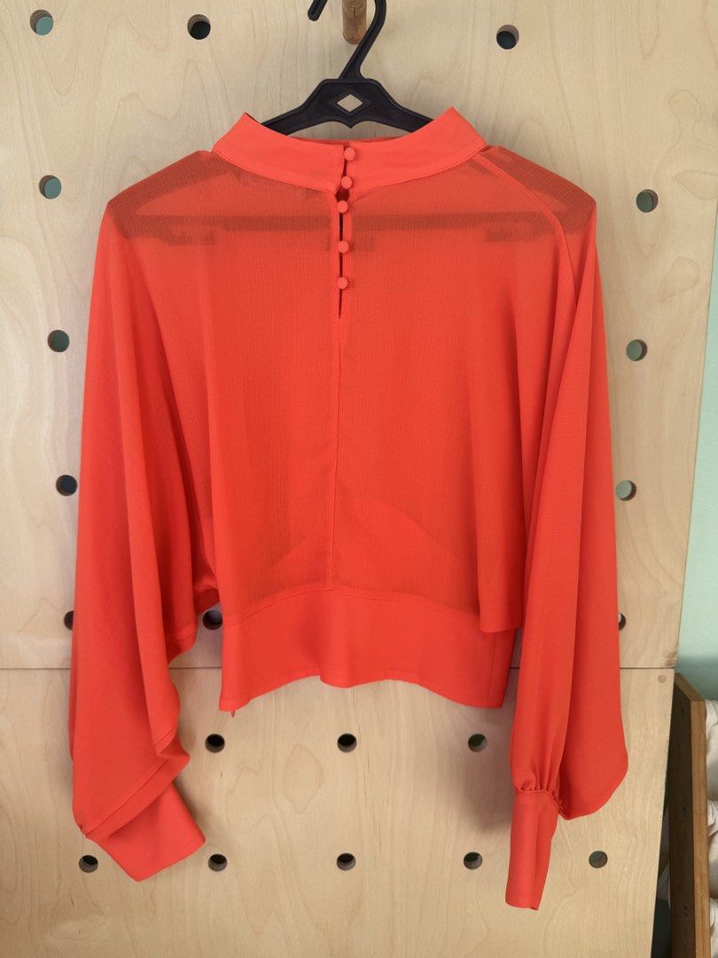ZARA Red High Neck Blouse Size S (Category: Blouses) located in Makati City. Submitted by thevclosetph (Listing ID 1470933249, Image 3). Description: - Brand: ZARA - Size: EUR S / USA S / MEX 26 - Color: Bright red (sheer fabric) - Details: High neckline, back button closure, long bishop sleeves with fitted cuffs, cropped fit - Origin: Made in Turkey.