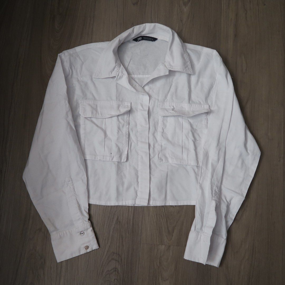 Zara White Cropped Shirt Size S (Category: Shirts) located in Manila. Submitted by mixi_lexi (Listing ID 1471034948, Image 1). Description: - Brand: Zara - Style: Cropped button-down shirt with long sleeves and button cuffs - Size: Small (EUR, USA, MEX tags) - Material: Lightweight cotton - Details: Two front flap pockets, made in Morocco - Condition: Clean, excellent everyday basic piece for layering or solo wear.