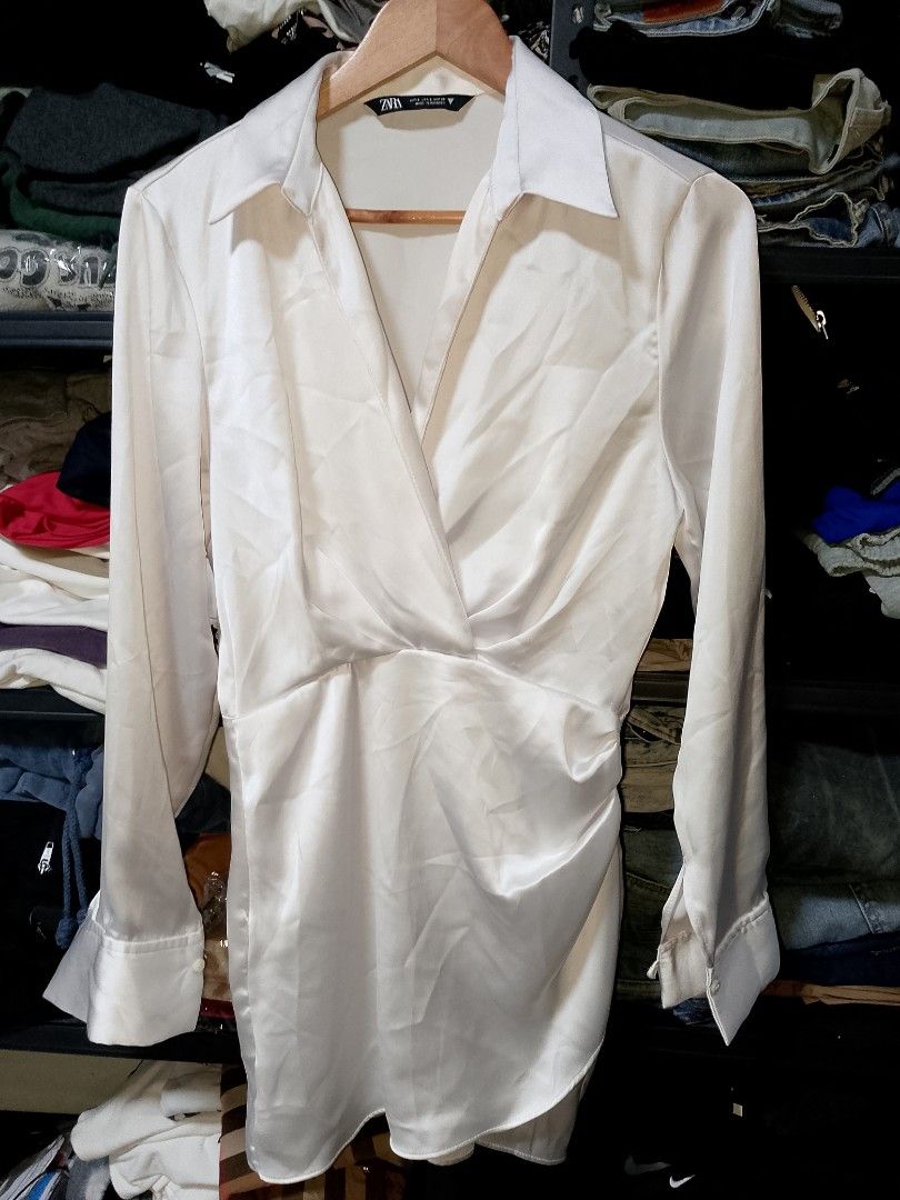 Zara White Satin Wrap Dress (Category: Dresses) located in Manila. Submitted by mjthrifted_second (Listing ID 1471032269, Image 1). Description: - Brand: Zara - Style: White satin wrap dress with long sleeves and button cuffs - Size: S (tag on collar and inside seam) -Dimes: 18/32 - Details: Classic pointed collar neckline, draped skirt, smooth fabric finish - Origin: Made in Morocco - Condition: Excellent, ready to wear.