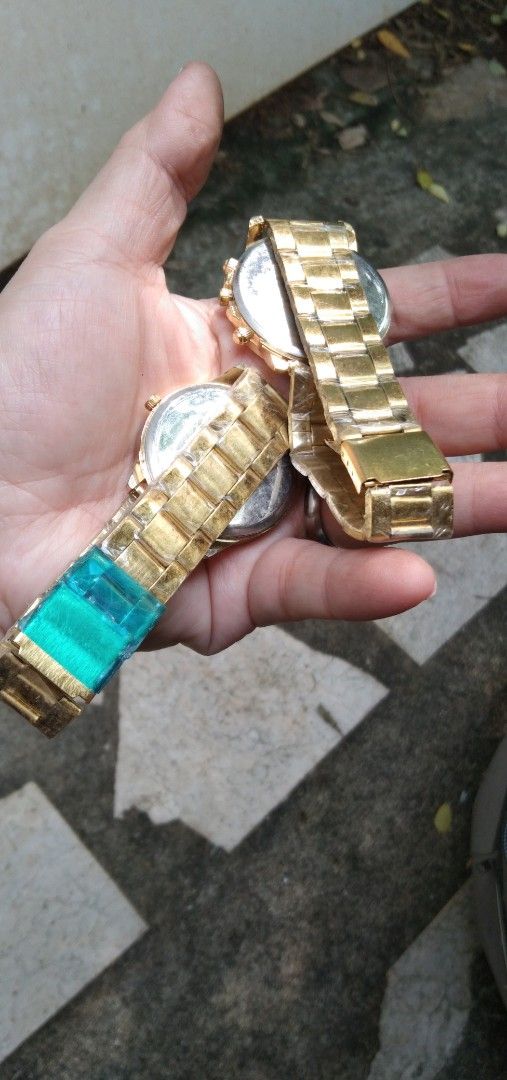 2 pcs watches Set old stock (Category: Women's Watches) located in Quezon City. Submitted by eidorableshop (Listing ID 1465703181, Image 3). Description: - Set of 2 brand new gold-tone wristwatches with protective plastic still attached - Left watch: Geneva brand, white dial, classic Roman numerals, and three decorative sub-dials - Right watch: Timeless Manila brand, rich dark brown dial with chronograph-style pushers - Straps: Matching metallic 