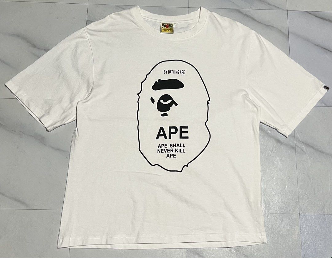 A Bathing Ape BAPE White Graphic Tee Size 2XL (Category: Tshirts & Polo Shirts ) located in Cavite. Submitted by christianzuuu (Listing ID 1465730432, Image 1). Description: - Dimes on actual photo - Brand: A Bathing Ape (BAPE) - Color: White - Size: 2XL (Measurements shown in photos) - Material: 100% Cotton - Design: Large Ape head graphic with 'Ape Shall Never Kill Ape' text - Condition: Brand new with classic collar and sleeve tags - Guarantee