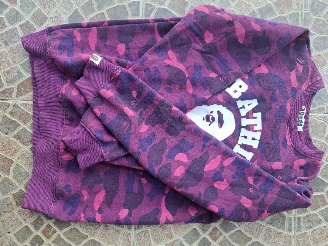 A Bathing Ape Purple Camo Sweatshirt (Category: Coats, Jackets and Outerwear) located in Manila. Submitted by baguioseller (Listing ID 1465636565, Image 3). Description: - Brand: A Bathing Ape (BAPE) - Item: Purple Camouflage Sweatshirt - Size: Large (L) - Material: 100% Cotton - Details: Large white front graphic with branding, ribbed cuffs and hem - Origin: Made in China - Condition: Excellent ready-to-wear piece.