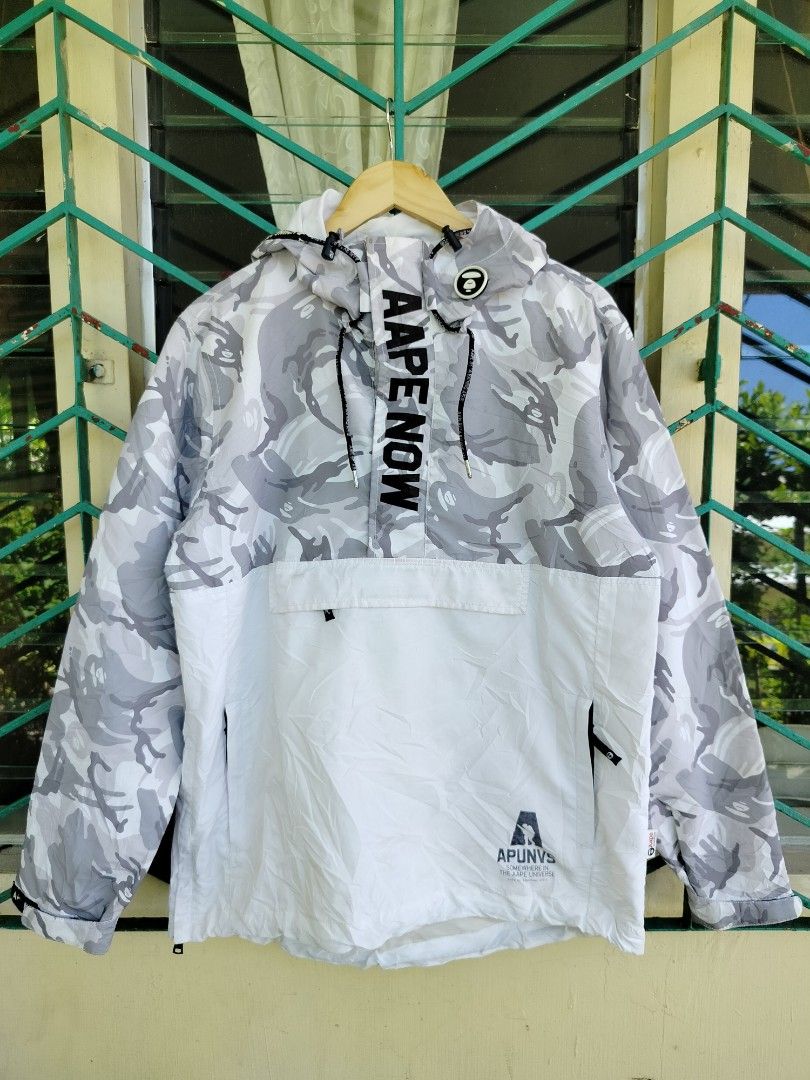 Aape By A Bathing Ape Camo Windbreaker Jacket (Category: Coats, Jackets and Outerwear) located in Manila. Submitted by gerald_quinto (Listing ID 1465708164, Image 1). Description: - Brand: Aape by A Bathing Ape - Style: Grey and white camo half-zip pullover windbreaker - Size: Large -Dimes 29×23.5 - Features: Adjustable hood, front pocket, and large 'Aape Now' front placket branding - Details: Contrast white lower panel with logo graphic, plus em
