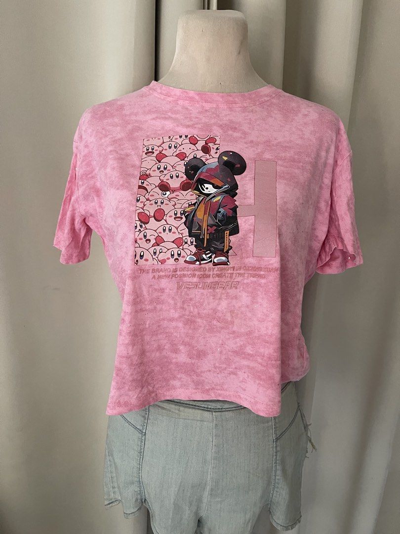 acidwash Kirby Graphic Crop Tee (Category: Shirts) located in Cainta. Submitted by zlove111 (Listing ID 1465585293, Image 1). Description: - Style: Streetwear cropped tee - Design: Pink tie-dye with cute Kirby characters and masked hoodie graphic - Details: "Vesunbear" text at the bottom - Fit: Cropped length, short sleeves, crew neckline - Condition: Excellent / As good as new - Shipping: Ships locally within the Philippines via J&T Express smal