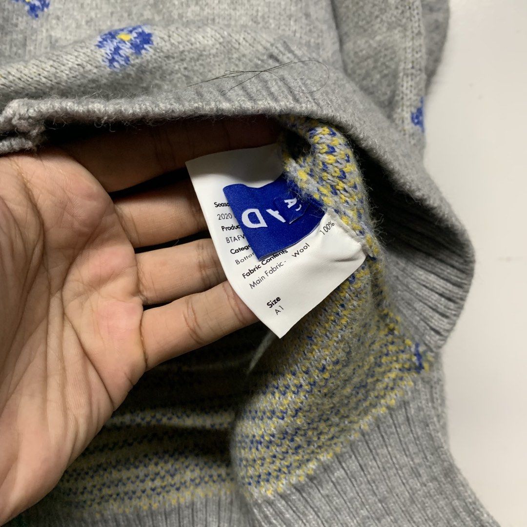 Ader Error Grey Wool Floral Cardigan Size A1 (Category: Coats, Jackets and Outerwear) located in Manila. Submitted by grapplers.gallery (Listing ID 1465742768, Image 3). Description: - Brand: Ader Error (2020 Season) - Item: Grey wool cardigan with all-over blue floral jacquard pattern and yellow center details - Material: 100% Wool - Size: A1 - Details: V-neck, button-up front with ADER branded buttons, and signature leather tag at the back neck