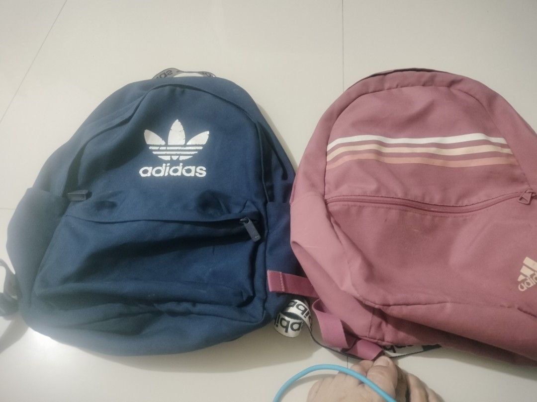 Adidas Backpack Bundle Set Blue and Pink (Category: Backpacks) located in Imus. Submitted by emershop (Listing ID 1465650112, Image 1). Description: - Authentic Adidas Backpack Bundle (Set of 2) - Colors: Classic Navy Blue & Dusty Rose Pink - Navy bag features a large trefoil logo and branded strap details - Dusty rose bag features a stylish striped pattern and subtle lower logo - Convenient front zippered pocket on both bags - Adjustable shoulde