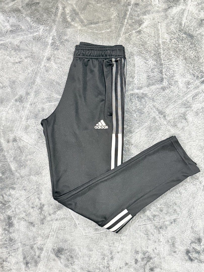 Adidas Black Track Pants with White Stripes (Category: Joggers) located in Tagaytay City. Submitted by belletrendss (Listing ID 1465654918, Image 1). Description: - Classic black Adidas track pants with iconic white stripes - Zippered side pockets to keep your essentials secure - Ankle zippers for an adjustable, customizable fit - Comfortable elastic waistband for all-day wear - Versatile staple piece ideal for workouts or streetwear.