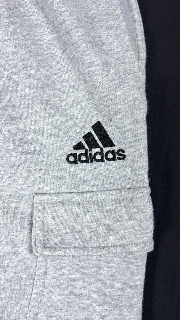 Adidas Grey Cargo Sweatpants Size 2XL (Category: Joggers) located in Bacoor. Submitted by calvinmanzano13 (Listing ID 1465617191, Image 2). Description: - L = 40.5” | W = 37” - Origin: Made in Cambodia - Features: Cargo pockets on both sides with Velcro closures - Logo: Embroidered black logo under the left pocket - Fit: Adjustable drawstring waistband and ribbed ankle cuffs Notes: ☑️ Hand washed ☑️ Polished ☑️ Steam ironed.