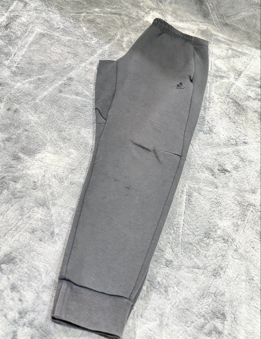 Adidas Grey Joggers Sweatpants Cuffed Ankle (Category: Joggers) located in Tagaytay City. Submitted by belletrendss (Listing ID 1465650585, Image 3). Description: - Brand: Adidas - Color: Grey - Features: Elastic waistband, ribbed cuffs, convenient side pockets, and black Adidas logo print - Condition: Minor fabric wear with tiny holes on the left leg near the knee - Best for: Lounging at home or casual workouts - PM for measurements or questions