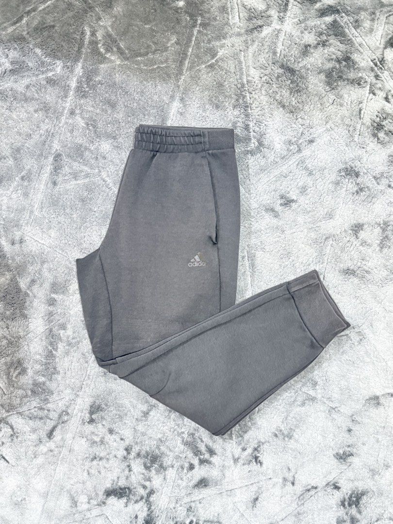 Adidas Grey Joggers Sweatpants Cuffed Ankle (Category: Joggers) located in Tagaytay City. Submitted by belletrendss (Listing ID 1465650585, Image 1). Description: - Brand: Adidas - Color: Grey - Features: Elastic waistband, ribbed cuffs, convenient side pockets, and black Adidas logo print - Condition: Minor fabric wear with tiny holes on the left leg near the knee - Best for: Lounging at home or casual workouts - PM for measurements or questions