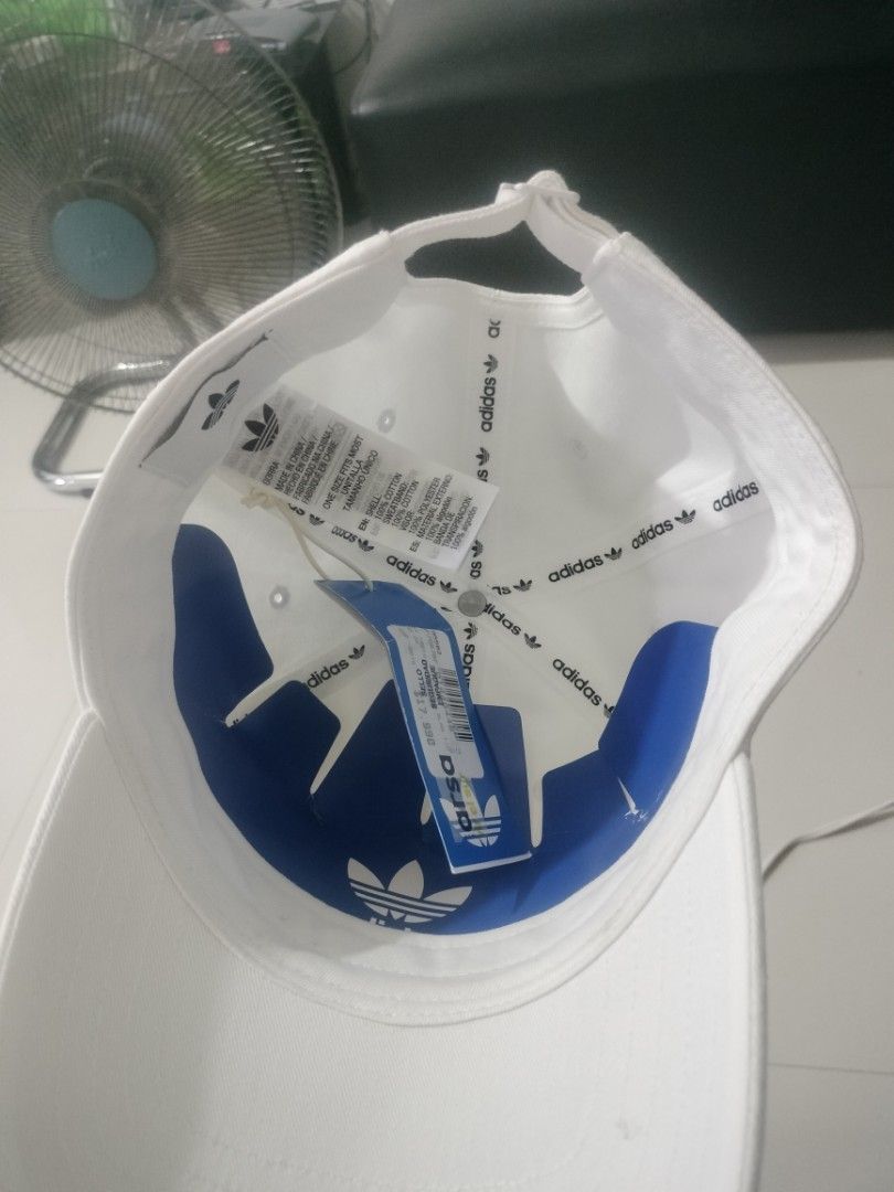 Adidas Trefoil White Baseball Cap Hat (Category: Caps & Hats) located in Imus. Submitted by emershop (Listing ID 1465648347, Image 2). Description: - Brand new with original tags still attached - Classic white design featuring a black embroidered Adidas trefoil logo - Made from 100% comfortable cotton for all-day wear - Adjustable back strap with subtle trefoil hardware for a custom fit - One size fits most with authentic blue inner branding tape