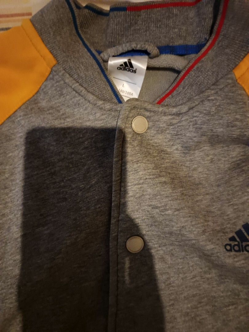 Adidas varsity jacket (Category: Activewear) located in Odiongan. Submitted by thriftngo26 (Listing ID 1465661846, Image 2). Description: appears to show an adidas gray and yellow snap-button knit baseball/varsity-style jacket with zippered side pockets..
