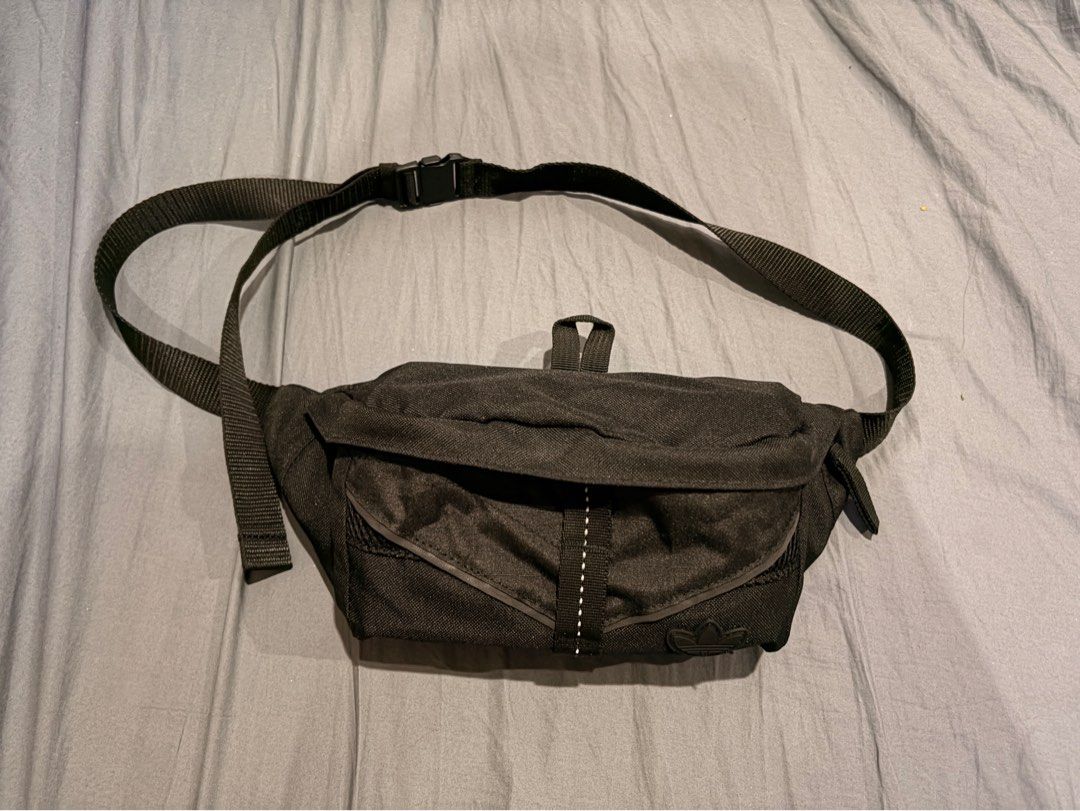 Adidas Running Bag (Waist Bag) (Category: Belt bags, Clutches and Pouches) located in Marikina City. Submitted by nj1989 (Listing ID 1465734150, Image 1). Description: - Brand: Adidas - Color: Classic Black - Material: Durable textured fabric with breathable mesh back panel - Storage: Main zippered compartment and front pocket with mesh detailing - Safety/Style: Classic rubber trefoil logo patch and reflective tape on the strap - Fit: Adjustable 