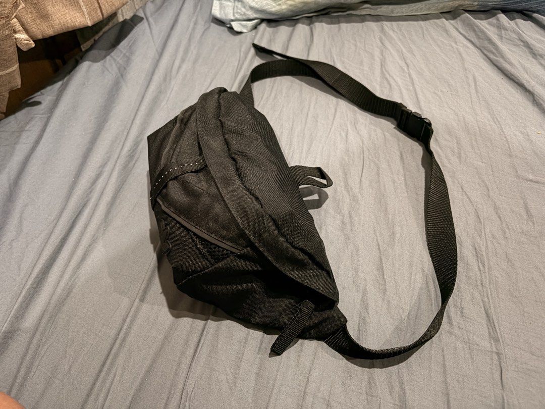 Adidas Running Bag (Waist Bag) (Category: Belt bags, Clutches and Pouches) located in Marikina City. Submitted by nj1989 (Listing ID 1465734150, Image 3). Description: - Brand: Adidas - Color: Classic Black - Material: Durable textured fabric with breathable mesh back panel - Storage: Main zippered compartment and front pocket with mesh detailing - Safety/Style: Classic rubber trefoil logo patch and reflective tape on the strap - Fit: Adjustable 