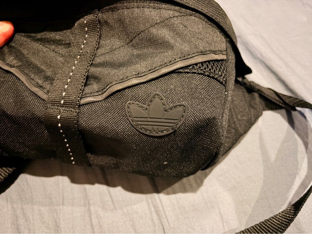 Adidas Running Bag (Waist Bag) (Category: Belt bags, Clutches and Pouches) located in Marikina City. Submitted by nj1989 (Listing ID 1465734150, Image 2). Description: - Brand: Adidas - Color: Classic Black - Material: Durable textured fabric with breathable mesh back panel - Storage: Main zippered compartment and front pocket with mesh detailing - Safety/Style: Classic rubber trefoil logo patch and reflective tape on the strap - Fit: Adjustable 