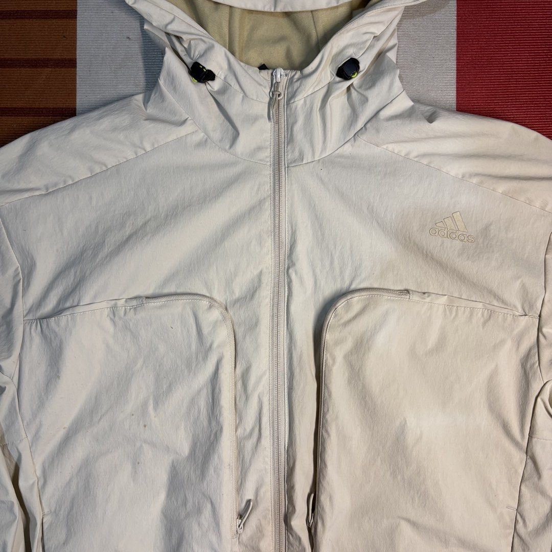 Adidas White Hooded Zip Jacket (Category: Coats, Jackets and Outerwear) located in Manila. Submitted by carlmachu (Listing ID 1465703708, Image 3). Description: - Brand: Adidas - Color: Off-white with subtle tonal logo - Size: L (Tag shown in photos) - Closure & Hood: Full front zipper with adjustable drawstring hood - Pockets: Large front utility pockets with secure zippered closures - Fit: Elasticated cuffs and hem for a snug fit - Note: Interi