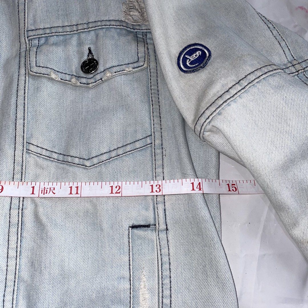 Alien Evolution Studio Distressed Denim Jacket Size S (Category: Coats, Jackets and Outerwear) located in La Trinidad. Submitted by ukaynirey (Listing ID 1465692904, Image 3). Description: Alien Evolution Studio denim jacket in light wash. Size S. Features distressing, zip front, and lace-up corset detail on the lower front. Embroidered patch on the left sleeve. Multiple utility pockets and woven brand patch near the hem. Unique streetwear piece 