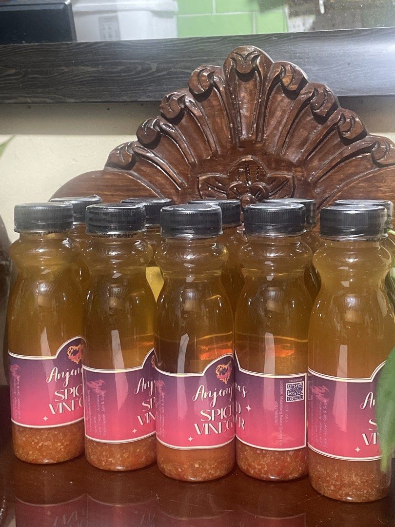 Anjeny's Spiced Vinegar Bottles (Category: Spice & Seasoning) located in Caloocan City. Submitted by mlin26 (Listing ID 1465706972, Image 1). Description: - Brand: Anjeny's Spiced Vinegar - Packaging: Clear bottle with secure black cap and vibrant purple-pink label - Quality Note: Visible natural sediment at the bottom, proving authentic ingredients - Availability: Multiple bottles in stock, ready to ship or meet up.