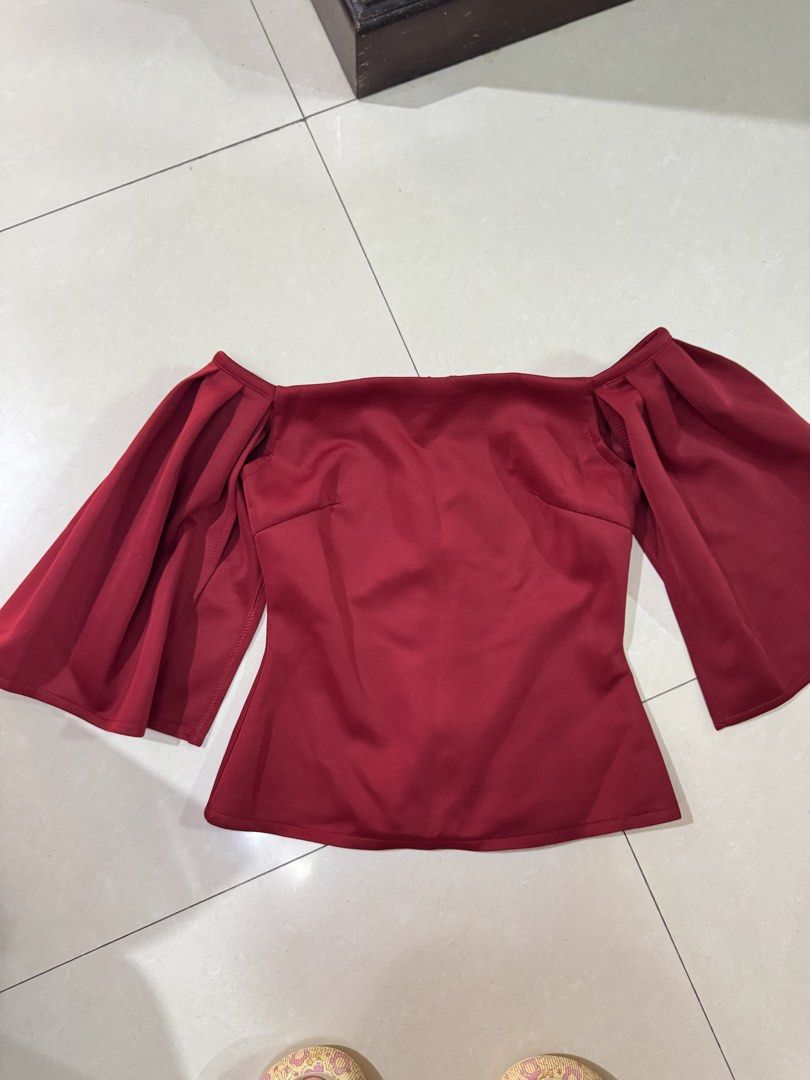 Apartment Eight Off-Shoulder Red Off shoulder (Category: Blouses) located in Quezon City. Submitted by sweetlyluxe (Listing ID 1465600203, Image 1). Description: - Brand: Apartment Eight - Style: Off-shoulder blouse with statement draped sleeves and fitted bodice - Color: Deep red, maroon - Size: S - Closure: Full zip closure down the back - Material: Smooth fabric with slight stretch - Condition: Clean and well-maintained.