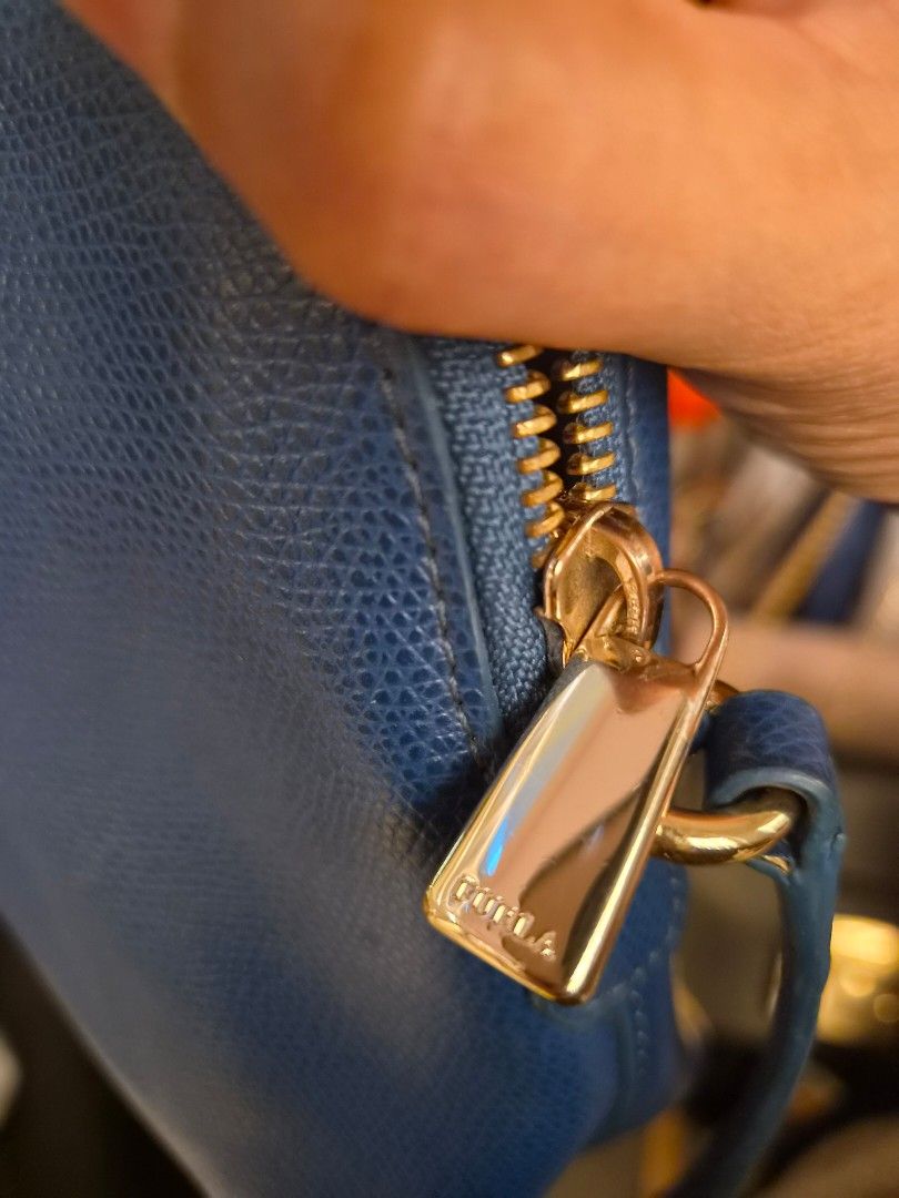 Authentic Furla Blue Crossbody Bag (Category: Cross-body Bags) located in Paranaque City. Submitted by regf_01 (Listing ID 1465666051, Image 3). Description: - Brand: Furla - Color: Blue - Material: Textured leather with silver-tone hardware - Style: Compact dome crossbody bag with top zipper closure - Strap: Adjustable thin strap - Interior: Clean lining - Condition: Excellent/Well-maintained/like new - Mode of Payment: GCash .