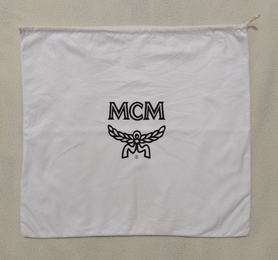 Authentic MCM White Cotton Drawstring Dust Bag – 16” x 17.2” (Category: Luxury Bags & Wallets) located in Santa Cruz. Submitted by oddpenguin-4575 (Listing ID 1465684100, Image 2). Description: 📌.....P L E A S E R E A D..... 📌measurement:L-16" /W-17.2" 📌color-9/10 📌Brand: MCM Color: White with black logo print Closure: Top drawstring Material: Cotton blend Condition: Excellent pre-owned condition with clean graphics (see photos for details) I