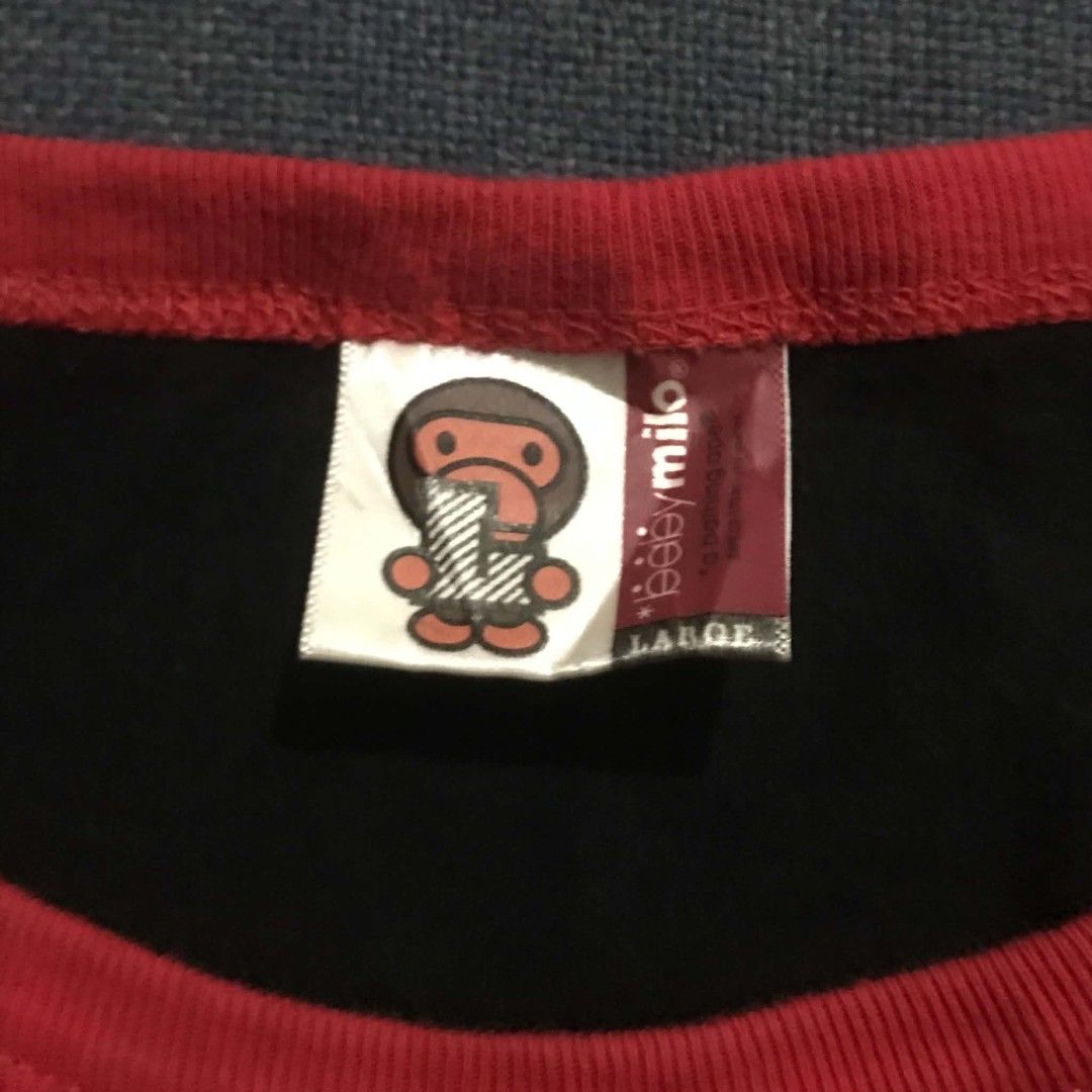 Baby Milo by A Bathing Ape Ringer Tee (Category: Shirts) located in Manila. Submitted by its_d4ve (Listing ID 1465688093, Image 3). Description: - Brand: Baby Milo - Color: Black with red ribbed collar and sleeve cuffs - Size: Large - Material: 100% Cotton - Design: Large Baby Milo sitting on clouds graphic on chest - Detailing: Small white Baby Milo logo on upper back neckline - Condition: Excellent / Pre-loved - Mode of Payment: GCash or BPI - 