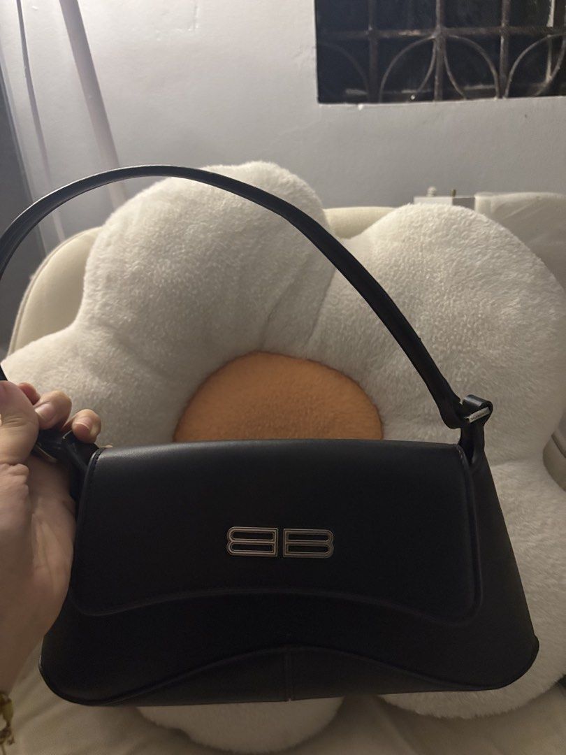 Balenciaga Black Shoulder Bag (Category: Luxury Bags & Wallets) located in Quezon City. Submitted by hadescloset (Listing ID 1465720639, Image 1). Description: - Brand: Balenciaga - Color: Classic Black - Material: Smooth leather - Hardware: Silver interlocking double B logo - Design: Single top handle with a structured silhouette and curved base - Condition: Clean interior and exterior - Style: Chic shoulder bag, perfect for any occasion.