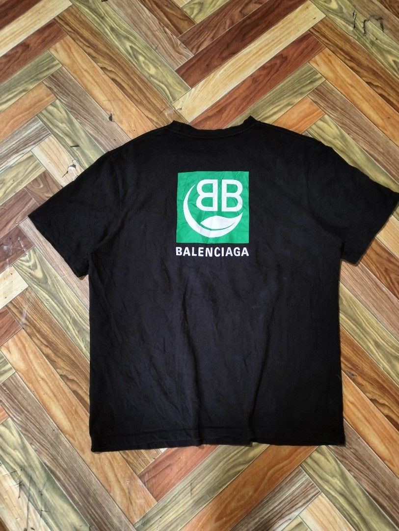 BALENCIAGA SHIRT (Category: Luxury Apparel) located in Solana. Submitted by allgoodst.s (Listing ID 1465715339, Image 1). Description: BALENCIAGA SHIRT large fitting 9/10 CR good condition black Balenciaga Eco Short Sleeve T-shirt featuring a green square graphic on the back with a white "BB" logo and a leaf symbol above the brand name Balenciaga..