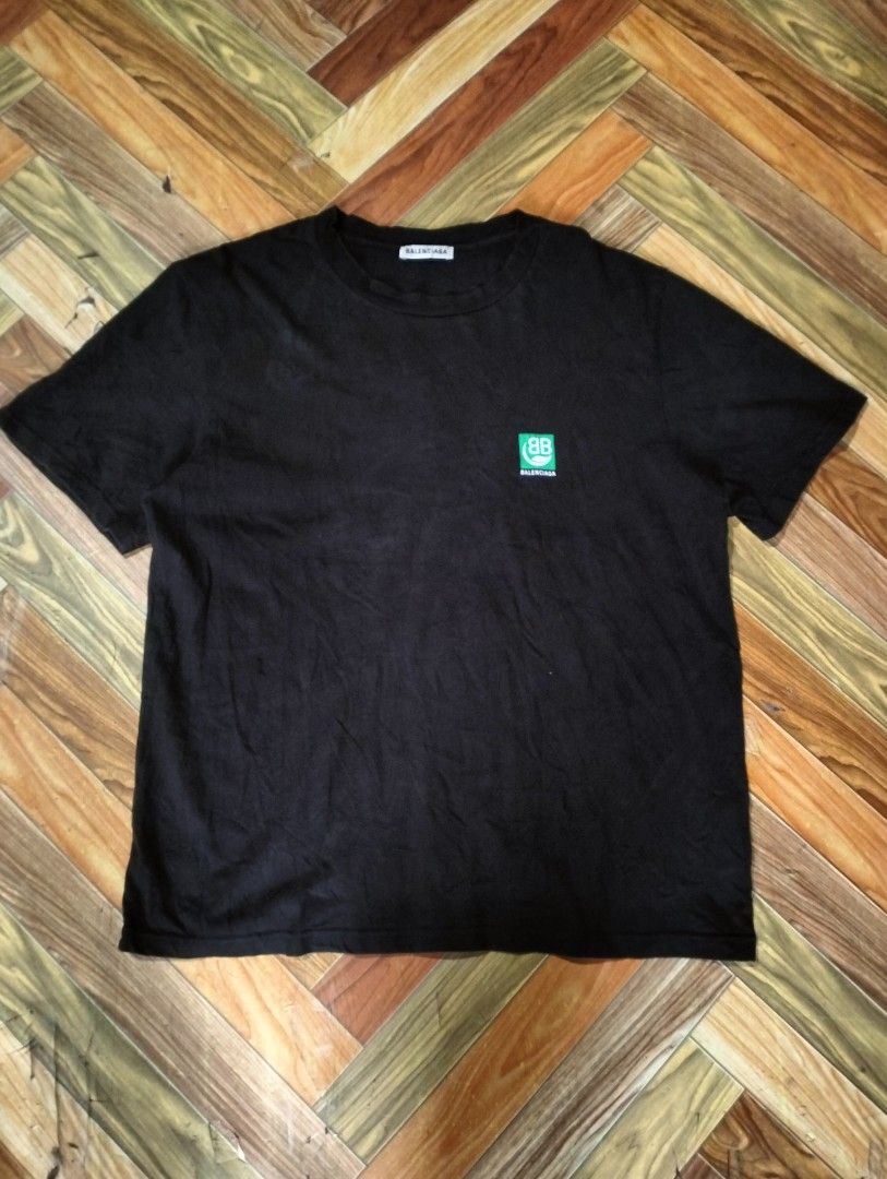 BALENCIAGA SHIRT (Category: Luxury Apparel) located in Solana. Submitted by allgoodst.s (Listing ID 1465715339, Image 2). Description: BALENCIAGA SHIRT large fitting 9/10 CR good condition black Balenciaga Eco Short Sleeve T-shirt featuring a green square graphic on the back with a white "BB" logo and a leaf symbol above the brand name Balenciaga..