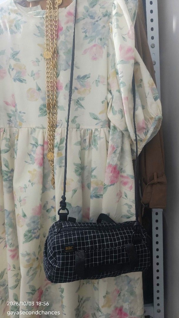 BBC Made in U.S.A. BLACK GRID MINI DUFFEL BAG (Category: Luxury Bags & Wallets) located in Kalibo. Submitted by secondchances.thriftsh8p (Listing ID 1465691239, Image 3). Description: - Color & Pattern: Black with a white grid pattern - Brand detail: Woven black label with 'BBC Made in U.S.A.' in gold lettering - Design: Trendy small barrel shape with dual top carry handles - Strap: Long, thin shoulder strap attached with durable metal rings - Cl