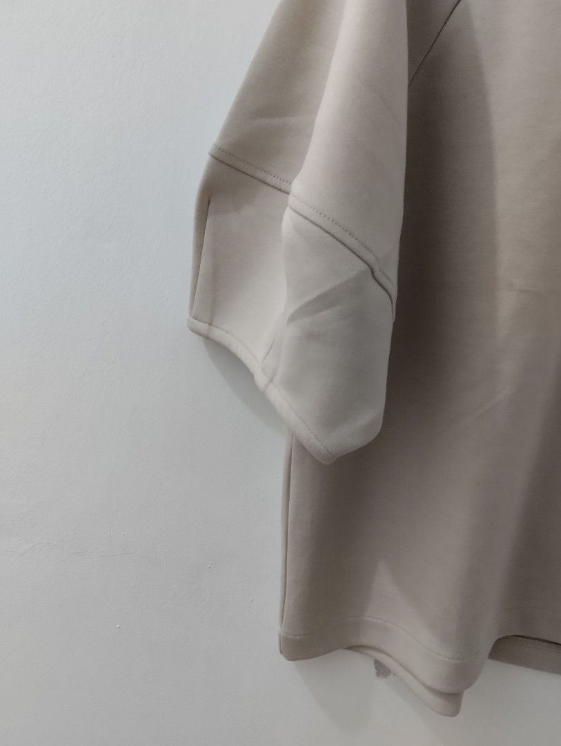 Beige Short Sleeve Raglan Blouse Top (Category: Blouses) located in Mabalacat. Submitted by uniqlover (Listing ID 1465639072, Image 3). Description: - Color: Neutral beige - Fit: Relaxed boxy fit with a classic crew neckline - Design: Structured raglan sleeves with cuffed hems - Material: Premium blend of 82% polyester, 14% rayon, and 4% polyurethane - Styling: Versatile piece, easily pairs with your favorite denim or work trousers.