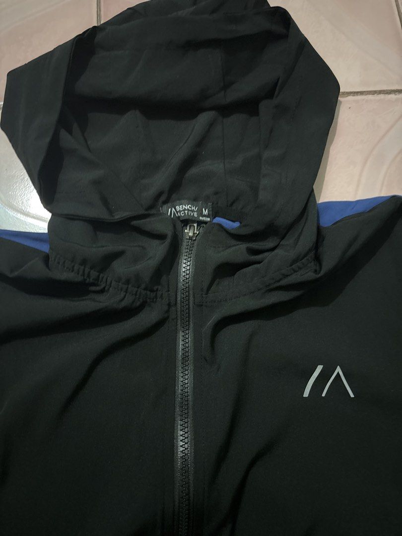 Bench Active Hoodie Jacket Black Green Blue Size M (Category: Coats, Jackets and Outerwear) located in Binan City. Submitted by fashion_claims (Listing ID 1465583362, Image 1). Description: - Brand/Model: Bench Active zip hoodie - Size: Men's Medium - Color: Black with bright green sleeves and blue accent panels - Features: Full front zipper, attached hood, elastic cuffs, hem, and chest logo print - Material: Lightweight fabric - Condition/Use: G