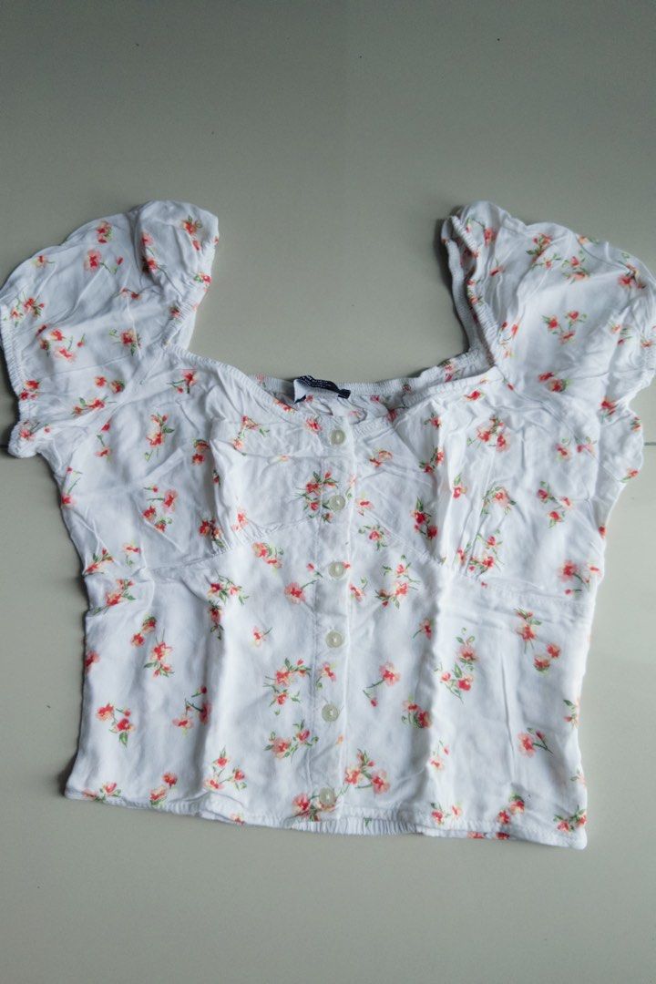 Bershka Floral Crop Top Size S (Category: Blouses) located in Manila. Submitted by deindichos79460 (Listing ID 1465651069, Image 1). Description: - Style: White crop top with an all-over red and pink floral print - Details: Sweetheart neckline, short puff sleeves, and a functional front button placket - Fit: Size S with a stretchy smocked back panel for ultimate comfort .