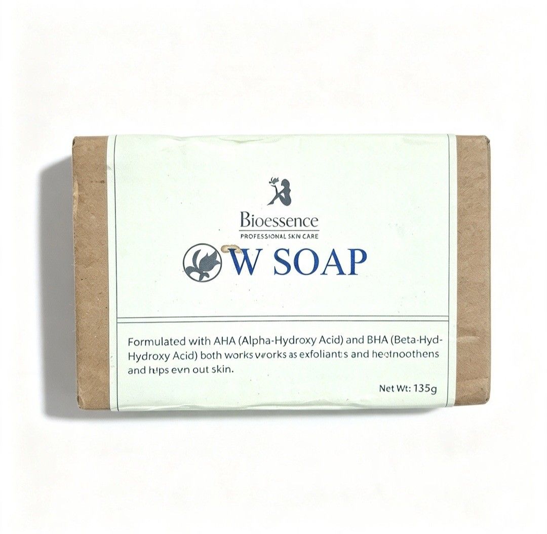 Bioessence W Soap AHA BHA (Category: Bath) located in Quezon City. Submitted by ana-chan (Listing ID 1465678252, Image 1). Description: Bioessence W Soap containing AHA and BHA for gentle exfoliation and evening out skin tone. Net weight 135 grams. Formulated with coconut oil, tea tree oil, anise oil, and salicylic acid. Includes storage instructions and manufacturing details on the packaging. Unopened paper wrap packaging, manufactured in the Ph