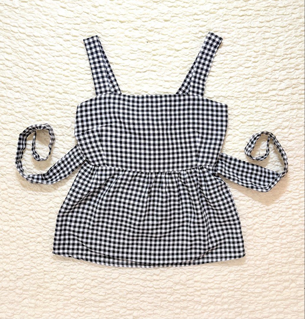 Black and White Gingham Peplum Top with Tie Back (Category: Sleeveless) located in Manila. Submitted by belles.clos3t (Listing ID 1465660781, Image 2). Description: - Design: Classic black and white gingham pattern - Neckline & Straps: Trendy square neckline with comfortable thick shoulder straps - Fit: Flattering fitted bodice with a flared peplum hem and adjustable back tie sashes - Style: Great casual piece for warm weather and everyday wear -